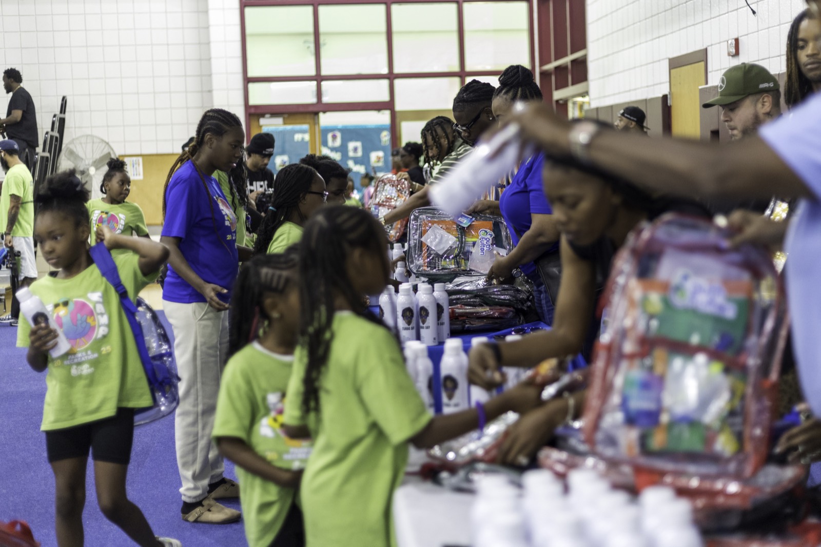 Kids picking up backpacks and school supplies at Turbo Day 2025