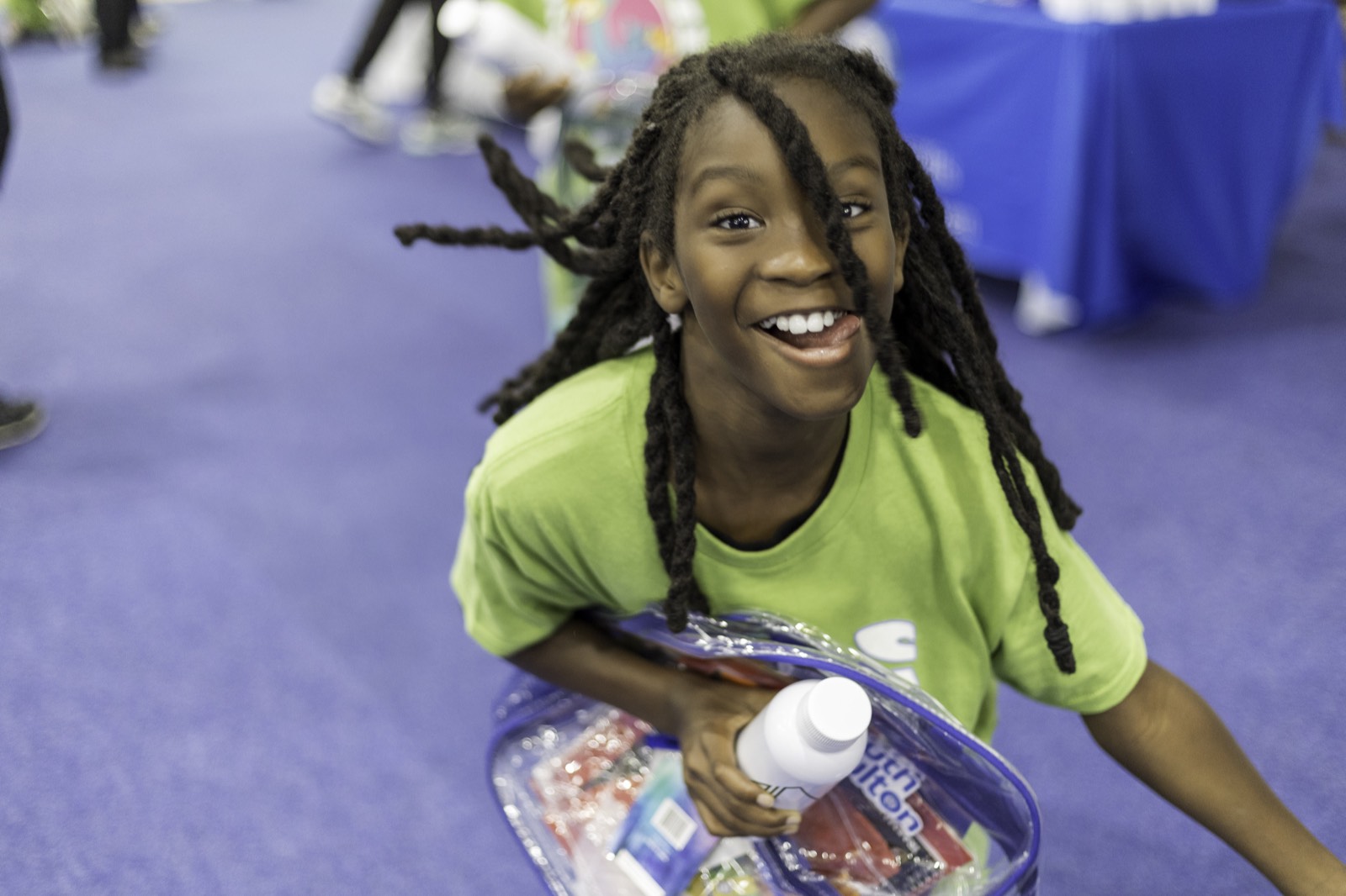 Kid smiling with backpack full of school supplies at Turbo Day 2025