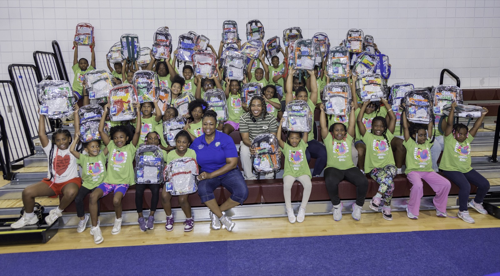 Kids holding up their new backpacks at Turbo Day 2025