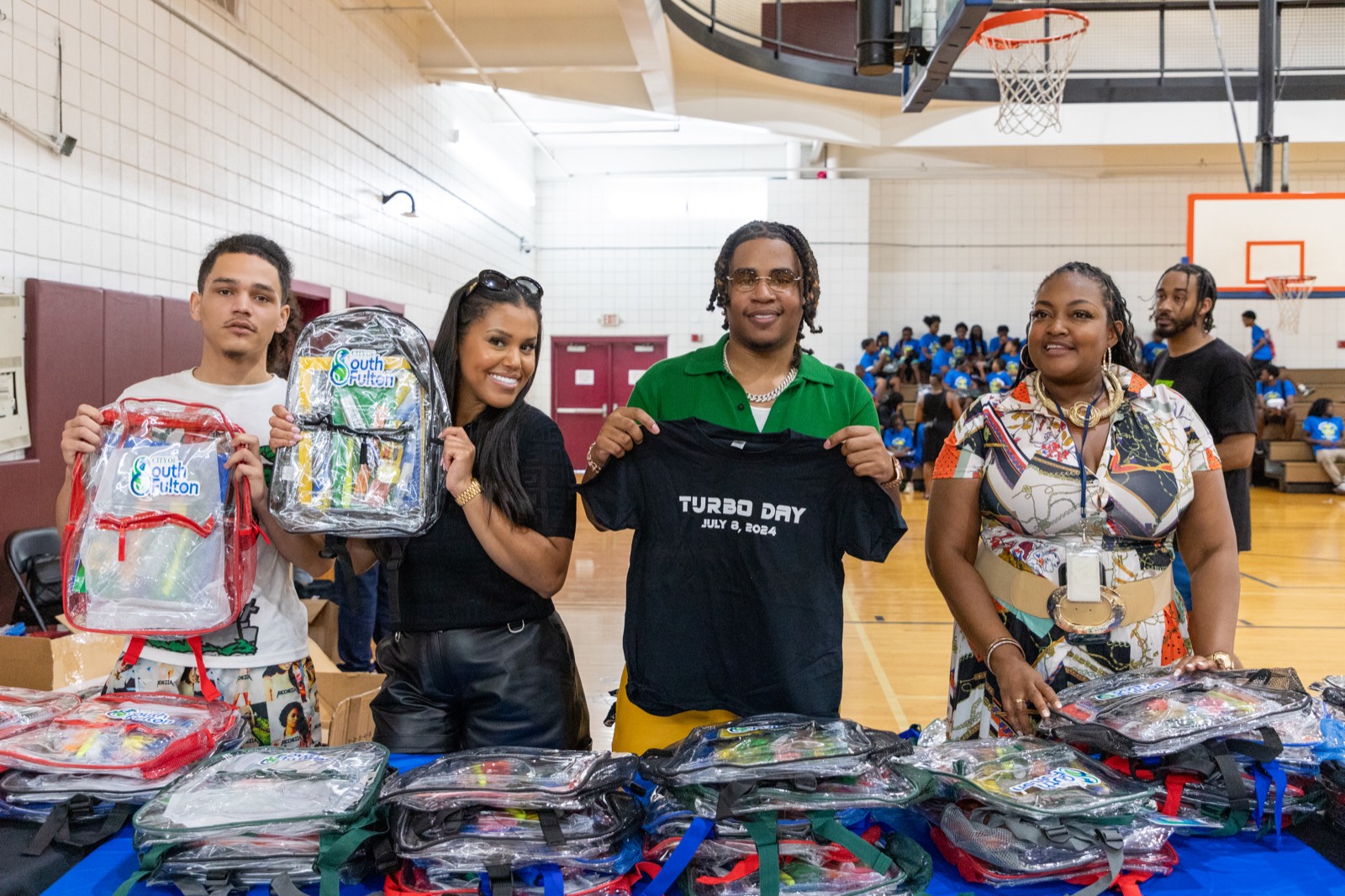 Turbo and team showing off bookbags and Turbo Day shirts