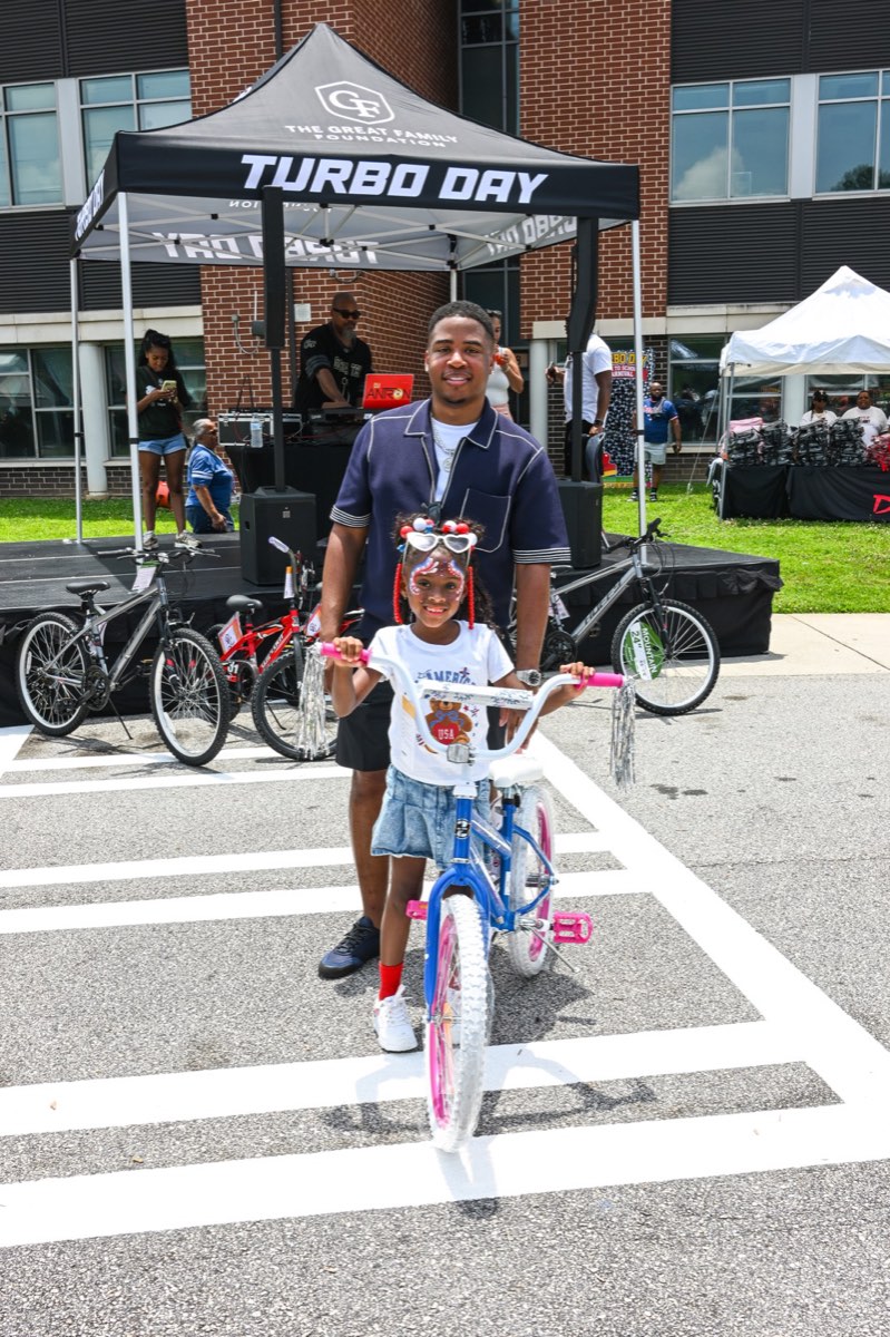 A young bike winner with her new bike at the Turbo Day 2026 tent