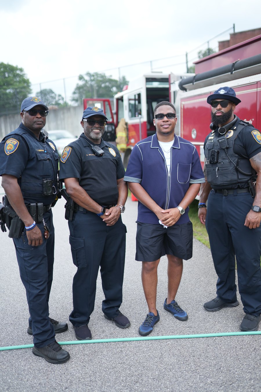 Turbo standing with College Park Police Department officers in front of a fire truck at Turbo Day 2026