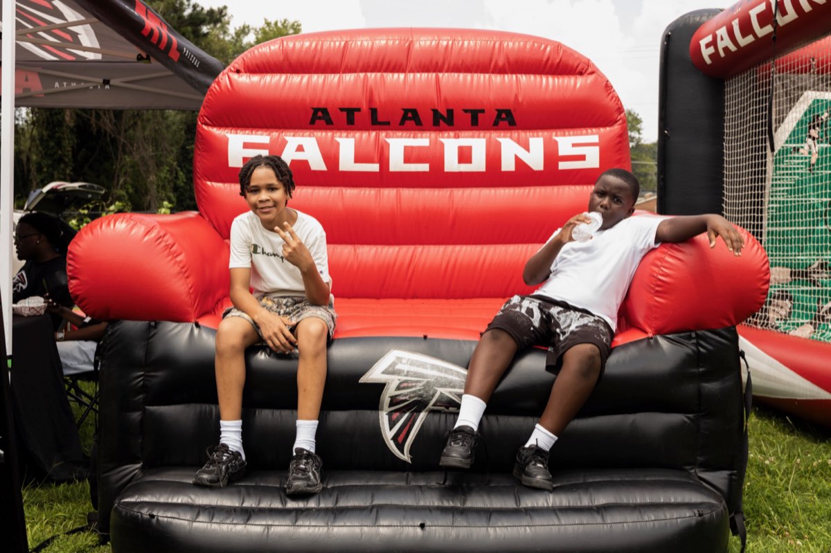 Two boys relaxing on the inflatable Atlanta Falcons couch at Turbo Day 2026