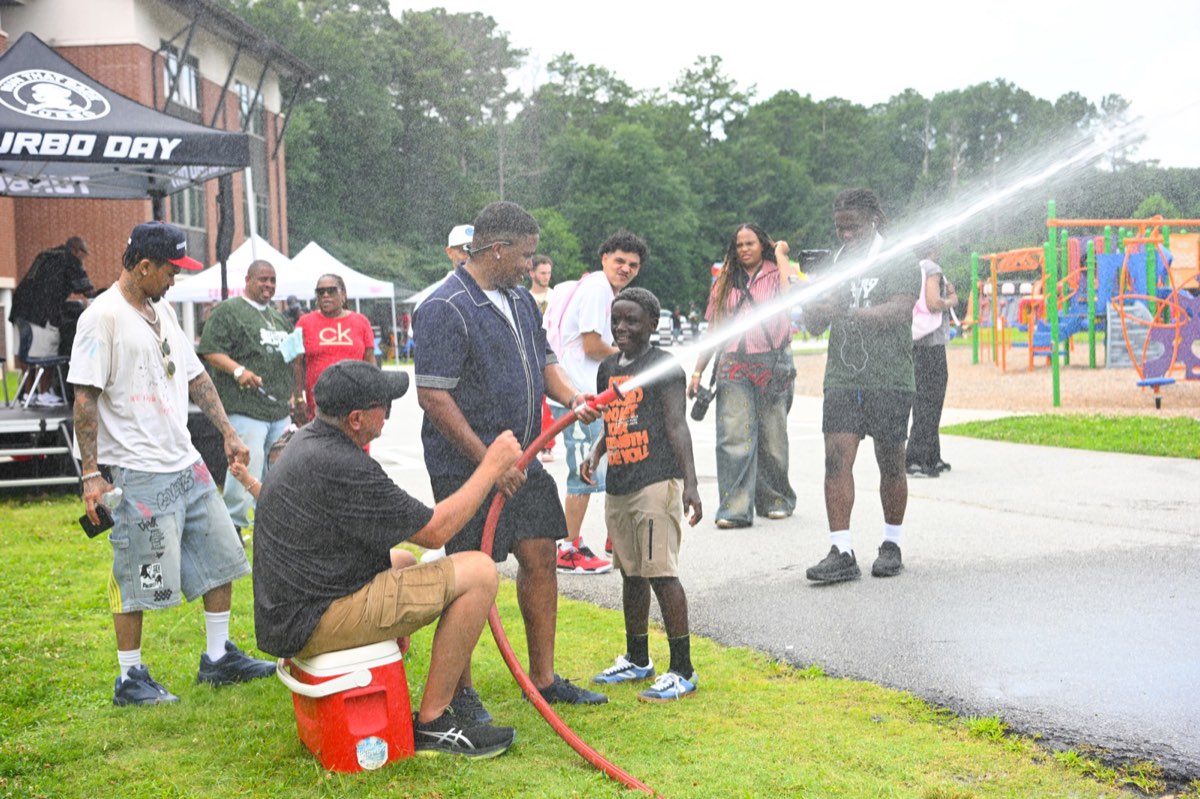 Kids cooling off in the spray from a fire hose at Turbo Day 2026