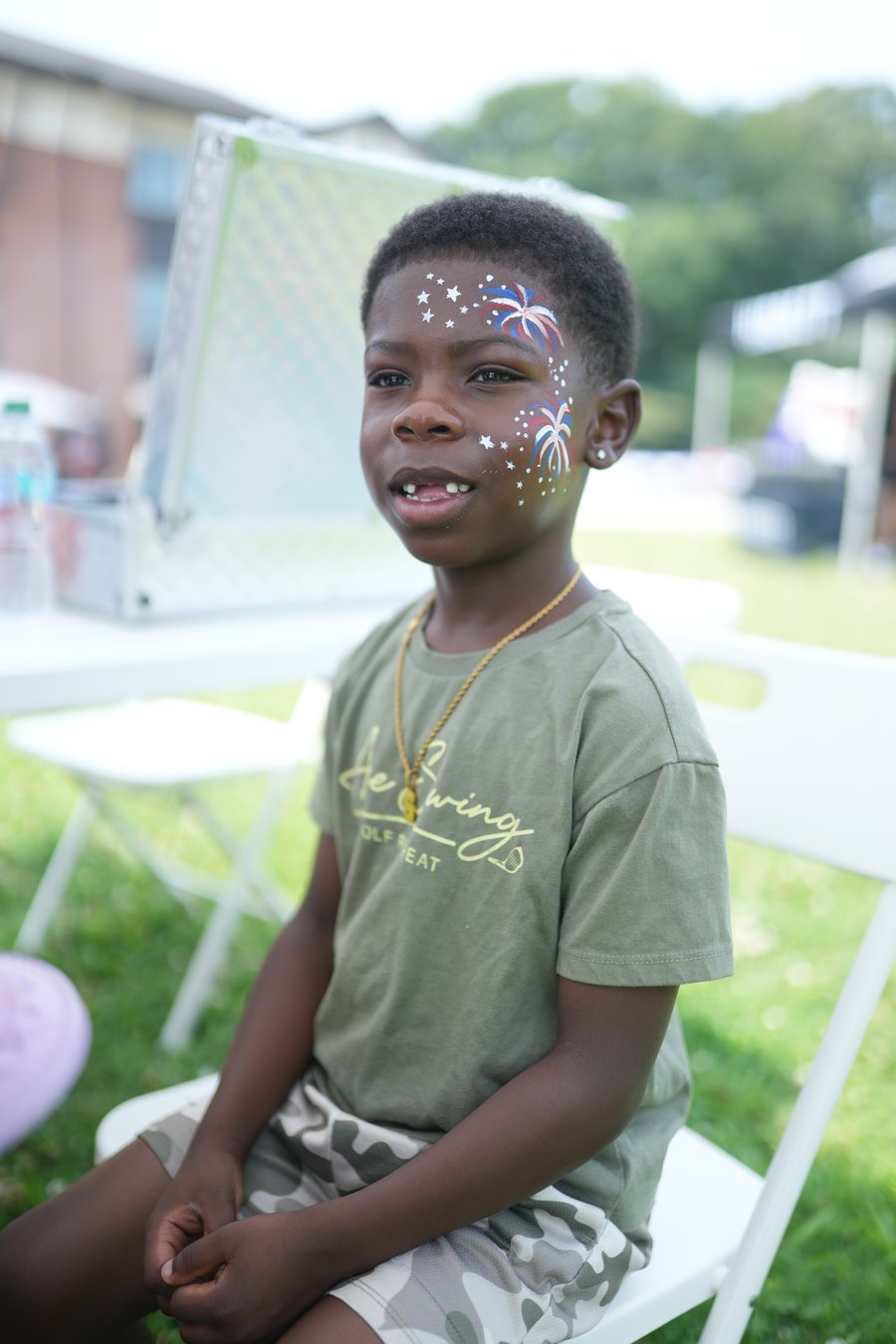 A young boy smiling with red, white, and blue firework face paint at Turbo Day 2026