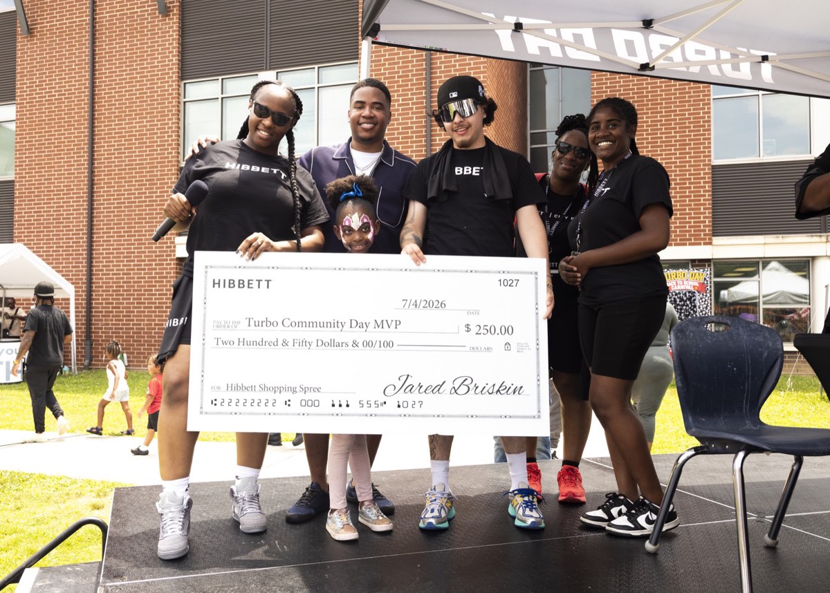 Hibbett presenting a $250 shopping spree check to a Turbo Community Day MVP at Turbo Day 2026